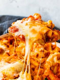 a slice of cheesy pasta being lifted from a casserole dish