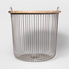 a blue wire basket with wooden top and handles on the bottom, in front of a white background