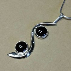 I fabricated this Sterling Silver Pendant to swirl around the two 10 mm round Black Onyx cabochon's.  The curved flowing silver gives motion to the piece.  It is 2-5/8 inches long × 3/4  inches wide. A very fun, yet elegant piece. I am including a Sterling Silver 18 inch long 8 sided Snake Chain so it can be worn immediately. Silver Round Cabochons With Polished Finish, Silver Round Elegant Cabochons, Elegant Silver Round Cabochons, Elegant Black Spiral Jewelry, Nickel-free Black Spiral Jewelry, Unique Black Spiral Jewelry, Black Obsidian Stone, Lapis Necklace, Sterling Silver Heart Pendant