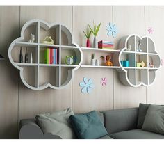 a living room filled with furniture and wall mounted bookshelves next to a gray couch