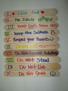 four wooden signs hanging on the wall with words written in different languages and colors,