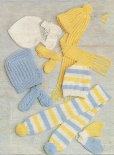 knitted hats, mittens and gloves laid out on a table with white background