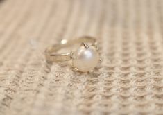 "Handmade sterling silver ring with a natural freshwater pearl. Dainty elegant ring, made by a jeweler with more than 25 years of jewelry design and creation experience. Please note, that each pearl is unique in its form, size, and color tone, therefore also each ring is unique and can slightly differ from the one in the pictures. If you would like to order the same design ring in bronze, gold-plated sterling silver, or 14-k gold, please, contact us! PRODUCT DETAILS -Diameter of the pearl: ca. 8 Fine Jewelry Pearl Ring With Prong Setting As Gift, Handmade White Gold Pearl Ring For Anniversary, Handmade Classic Pearl Ring As A Gift, Handmade Classic Pearl Ring For Gift, Handmade Classic Pearl Ring As Gift, Fine Jewelry Pearl Ring With Round Band Gift, Fine Jewelry Solitaire Pearl Ring Gift, Sterling Silver Solitaire Pearl Ring For Anniversary, Elegant Hand Forged Moonstone Ring Gift