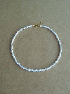 "This White Beaded Choker is so simple and elegant. It can wear alone or layer with other chokers, in any case, it is perfect for any outfit. This listing for ONE WHITE CHOKER. DETAILS - Japanese glass seed beads 4 mm - Quality strong nylon string - Choker length. Choose in the drop down menu - Lobster or round clasp closure. Available gold tone (default) or silver tone (by request) - Extension (adjustment) is 1 inch (2.5 cm). If you need longer, please, leave a note when ordering - Comes in a s Minimalist White Choker For Everyday, Minimalist White Everyday Choker, Everyday Minimalist White Choker, White Beaded Chain Necklace For Everyday, White Necklaces With Tiny Beads For Everyday, Everyday White Single Strand Beaded Necklace, Adjustable White Choker For Everyday Wear, Simple White Round Beads Jewelry, Simple White Round Bead Jewelry