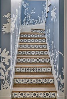 the stairs are decorated with blue and white wallpaper, which is painted with floral designs