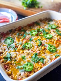 a casserole dish with cheese, green peppers and meat in it on a table