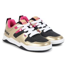 Gold and black trainers for girls by DKNY. Made from soft leather and canvas, they feature the brands logo print in black on the sides and a logo print on the heels. Fasten with white laces and have faux leather inner soles and non slip rubber outer soles. Comes with branded box.  #dknykids #girlssneakers #goldtrainers #fashionfootwear Toddler Girl Accessories, Gold Trainers, Boys Sleepwear, Leather And Canvas, Girls Sleepwear, Boys Swimwear