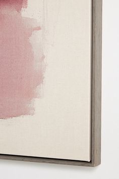 an abstract painting with pink and white colors on the wall in front of a light colored background