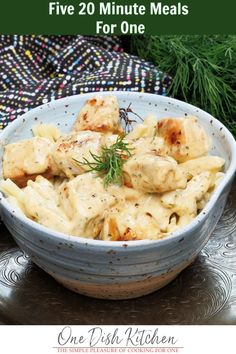 a blue bowl filled with pasta and chicken