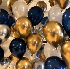 a bunch of balloons that are in the shape of heart shaped balloons with gold, silver and blue colors