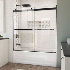 a bathroom with white tile and wooden floors