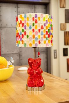 a gummy bear lamp sitting on top of a table next to a bowl of fruit