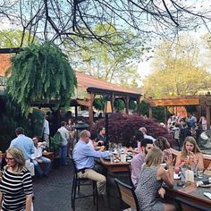 many people are sitting at tables outside eating