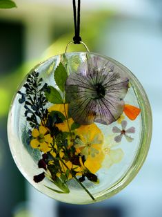 a glass ornament with flowers and leaves in it