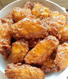 a white bowl filled with fried food on top of a table