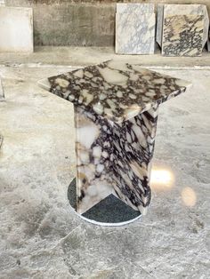 a marble pedestal sitting on top of a cement floor