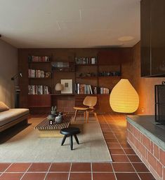 a living room filled with furniture next to a fire place and bookshelf on the wall