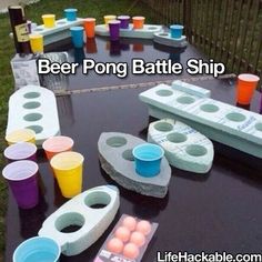 there are many different colored cups on top of the ping pong table ship game