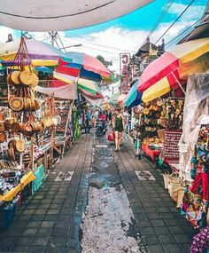 an outdoor market with umbrellas and other items