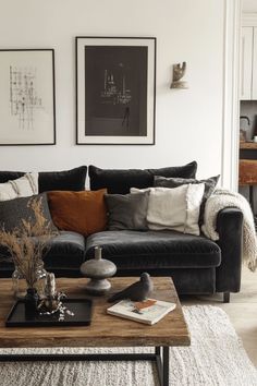 a living room with black couches and white rugs on the floor next to a coffee table