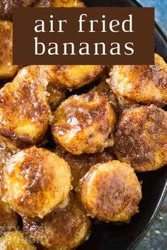 air fried bananas in a black bowl with cinnamon on top and the words, air fried bananas