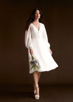 a woman in a white dress holding a bouquet