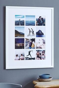 a white framed photo hanging on the wall next to a bowl and vase with flowers