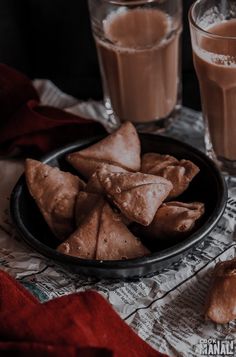 some food is sitting on a table next to two glasses