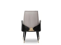 an upholstered chair with black leather and gold trimmings on the legs