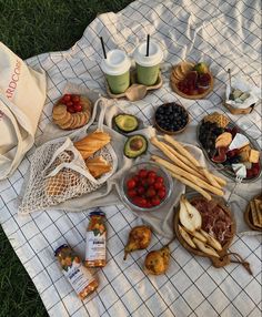 a table topped with lots of food on top of a blanket