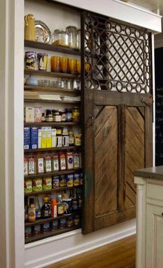 an open pantry door in the middle of a kitchen with lots of spices and condiments