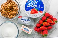 ingredients to make pretzels, strawberries and yogurt on a marble counter top