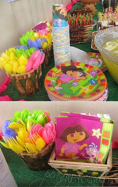 there are many colorful plates and cups on the table at this children's birthday party