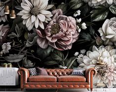 a couch sitting in front of a wall with flowers on it