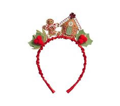 a red headband with christmas decorations and gingerbread house on it's side