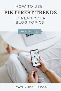 a person sitting on a couch holding a cell phone and looking at their laptop with the text how to use pinterest trends to plan your blog topics in the blog