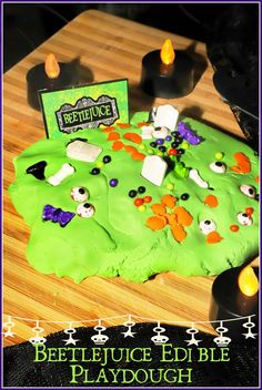 a halloween themed cake with candles on the side and a sign that says beetlejuice edible playdough