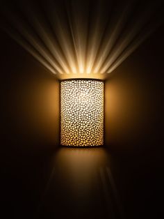 a light that is on the side of a wall with some lights coming from it