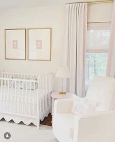 a baby's room with a white crib and two framed pictures on the wall