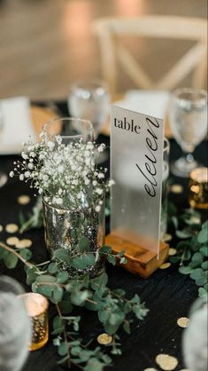 the table is set up with place cards and vases filled with baby's breath