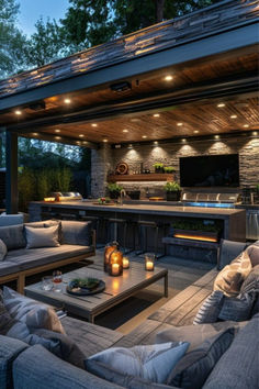 an outdoor kitchen and living room are lit up at night