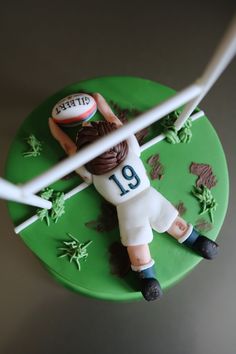 a cake shaped to look like a football player is being held by two white sticks