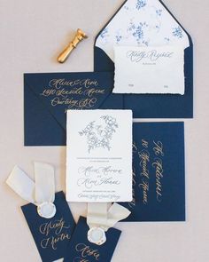 the wedding stationery was done in navy blue and white with gold calligraphy on it