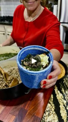 a woman holding a blue bowl filled with food