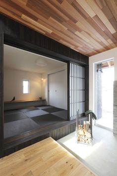 an empty room with wood paneling on the ceiling and windows in the back ground