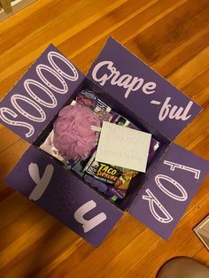 a purple box that has some kind of stuff inside of it on the wooden floor