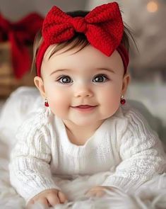 a baby girl wearing a red bow on her head