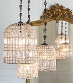 three lights hanging from a chandelier in front of a mirror