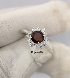 Vintage Garnet Cluster Ring, 6mm Round Ring, Red Garnet Engagement Ring, Promise Ring, Genuine Garnet Ring, Birthstone Ring, Stately Garnet ★ Settings ☆ Metal - 925K Sterling Silver ☆ band Color - White ★ Main Stone ☆ Stone - Garnet ☆ Size - 6mm ☆ Shape - Oval ☆ Side Stone -CZ Diamonds ★ Features : ☆ Handmade & Made to order. ☆ Ready to ship in 2-3 Business days. ☆ Complimentary gift wrapping. ☆ Free insured worldwide shipping. ★ Links : ☆ Check out my shop - https://rjjewells.etsy.com ★ Notes : Garnet Engagement Ring, Ring Birthstone, Garnet Ring, Round Rings, Ring Promise, Garnet Rings, Cz Diamond, Sterling Silver Bands, Red Garnet