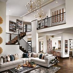 a living room filled with lots of furniture and a stair case in the middle of it